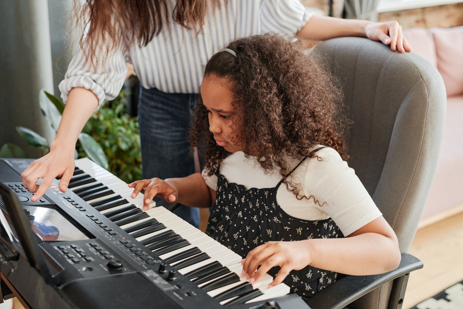 Une jeune fille apprenant le piano lors d'un cours avec son professeur
