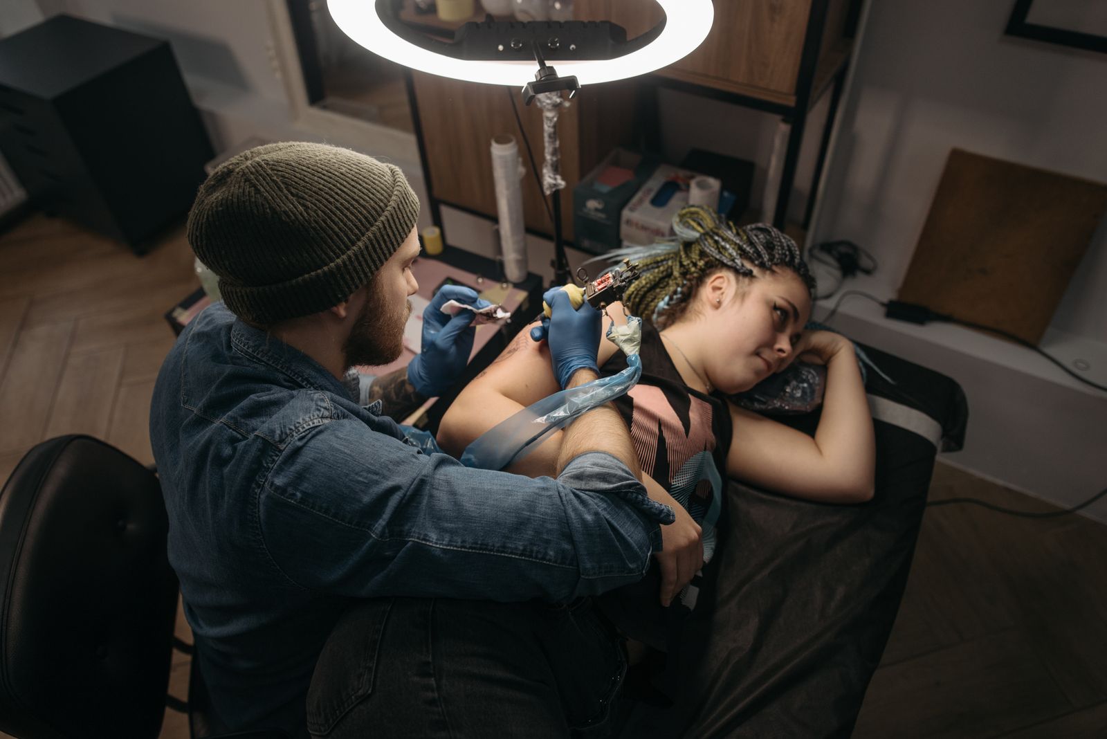 Un tatoueur travaillant sur le bras d'un client dans un studio moderne