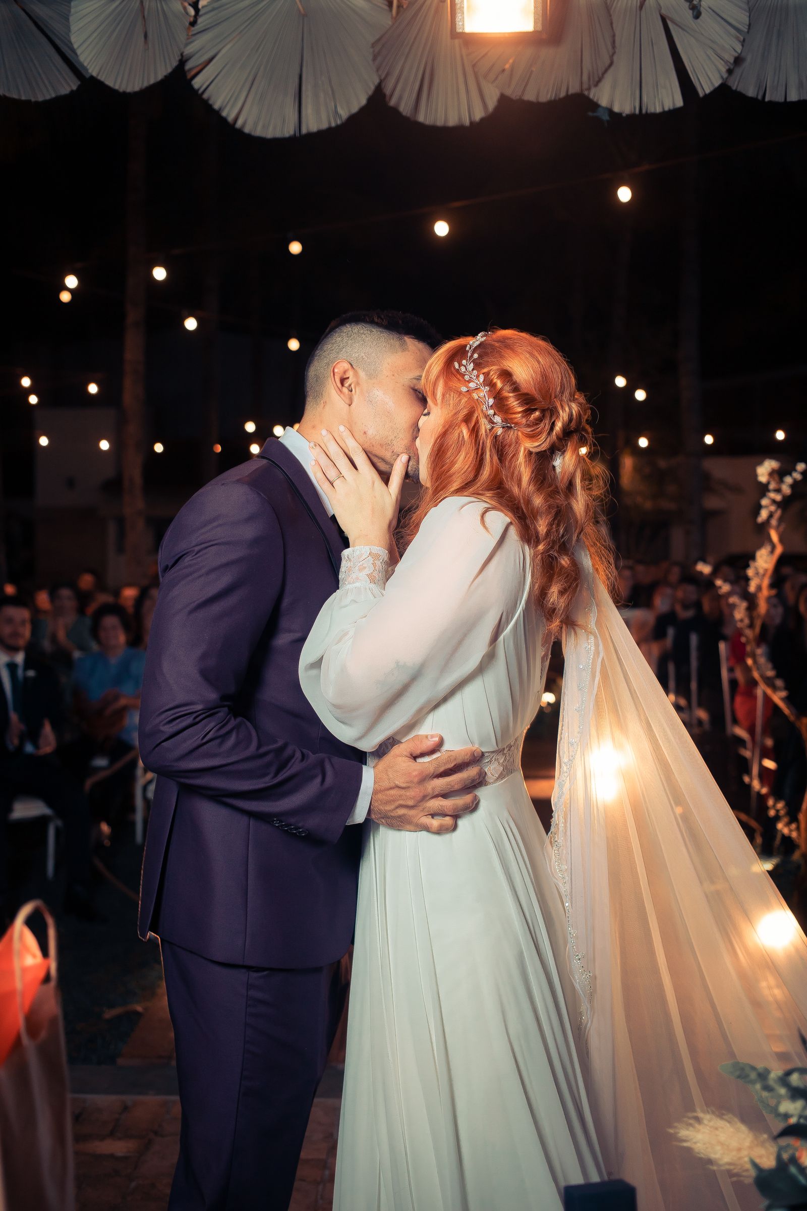 Des mariés partageant un baiser lors de leur cérémonie de mariage en plein air